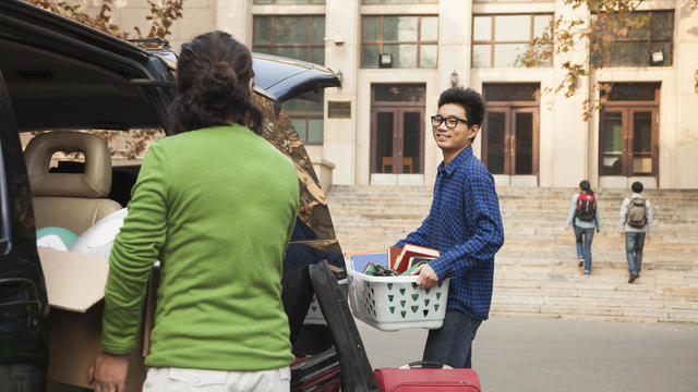 Young man moving into dormitory on college campus 