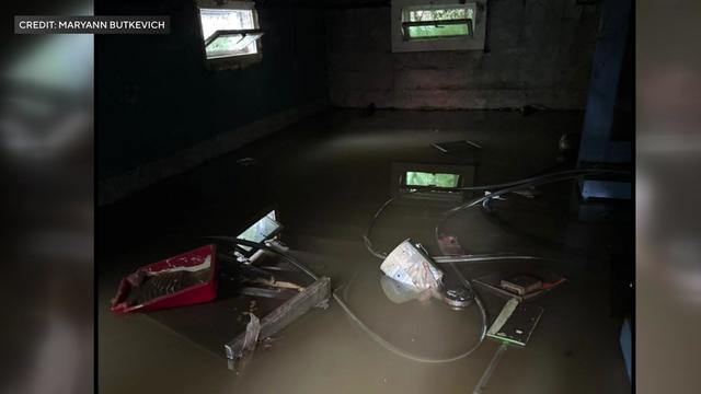 Belongings floating in floodwaters inside what appears to be garage 